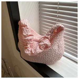 Détail du sac bandoulière rose texturé popcorn avec bandoulière plissée et zip