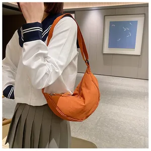 Detailopname van de oranje nylon halve maan tas crossbody gedragen voor de maat