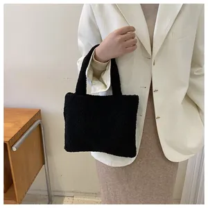 Close-up of black plush handbag showing soft faux fur texture and stylish handle