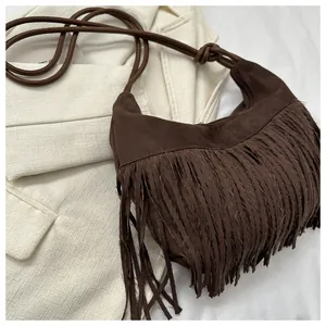 Detailed view of deep brown suede crossbody bag with long fringe tassels and hobo design
