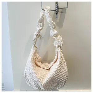 Détail du sac hobo blanc crème avec texture gaufrée et fermeture éclair métallique