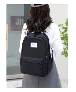 Minimalist black backpack for students featuring large capacity and side pockets shown on back