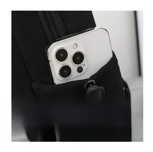 Detail of a side storage pocket on a black nylon chest bag with a white smartphone inside