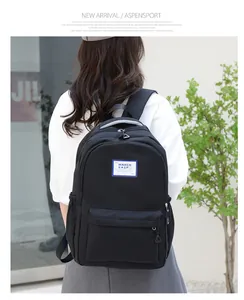 Detail of minimalist black backpack featuring padded straps and a side water bottle pocket