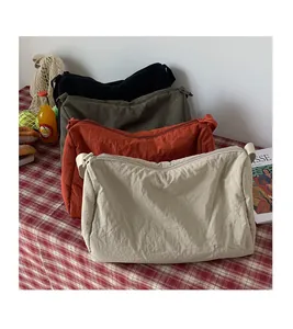 Gros plan de sacs bandoulière légers en nylon en noir, vert, rouille et beige