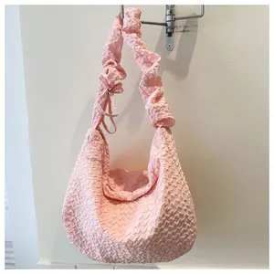 Détail du sac hobo rose à texture bulle avec bandoulière nuage et nœud décoratif