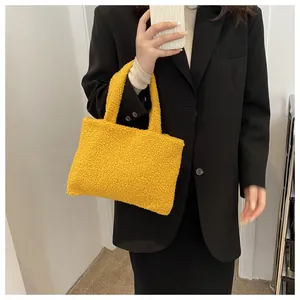 Detail of yellow plush fleece tote bag held by model wearing a black suit jacket