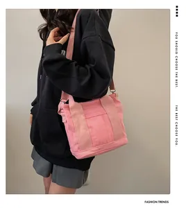 Borsa tote in tela rosa con tasca frontale e tracolla regolabile indossata da modella