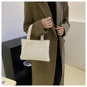 Close-up of plush white lambskin tote bag with soft faux fur texture for winter style