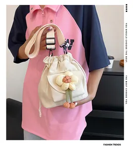 Detail of canvas mini bucket bag featuring 3D floral accents and adjustable strap