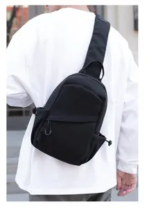 Man wearing a black minimalist nylon sling bag in a city setting for daily outdoor casual use