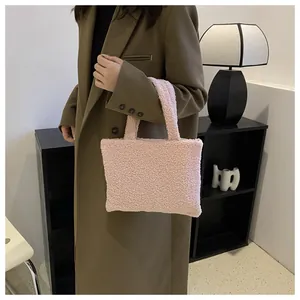 Detailed side view of a pink plush tote bag held by a model in a minimalist setting