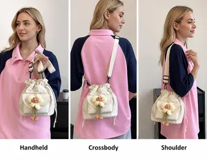 Detail view of canvas bucket bag showing three ways to wear: handbag, crossbody, and shoulder