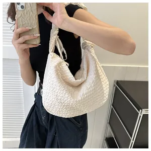 Détail du sac à bandoulière blanc crème à texture popcorn et surface en tissu plissé