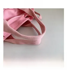Dettaglio dei manici in tela rosa resistente su una borsa a mano alla moda