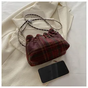 Détail du sac nuage à carreaux rouge-brun avec chaîne et smartphone pour comparer la taille