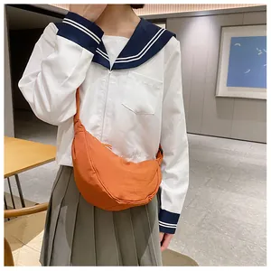 Detailweergave van de oranje nylon halfmaanvormige crossbodytas met verstelbare riem