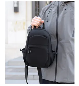 Close-up of black nylon chest bag with zipper pocket and elastic side mesh compartments