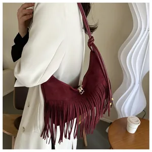 Detail showing burgundy suede hobo bag with bohemian long fringe and knotted strap design