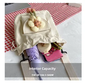 Internal capacity of mini canvas drawstring bucket bag showing umbrella and wallet