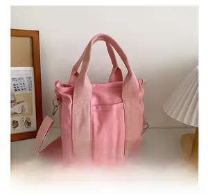 Borsa in tela rosa con tracolla regolabile, manico e tasca anteriore in un interno