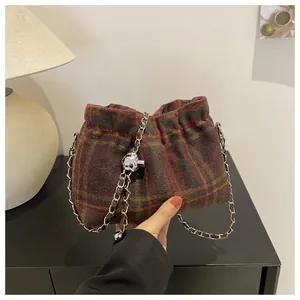 Détail du sac en laine à carreaux avec breloque crâne argentée et chaîne en cuir