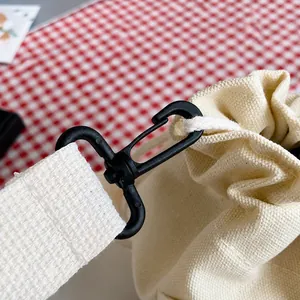 Detailed macro shot of the durable black swivel hook on a minimalist canvas bucket bag