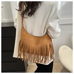 Detailed back view of a brown suede tassel crossbody bag with a bohemian crescent design
