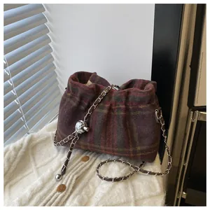 Détail du sac seau à carreaux rouges avec chaîne argentée et boule métallique réglable