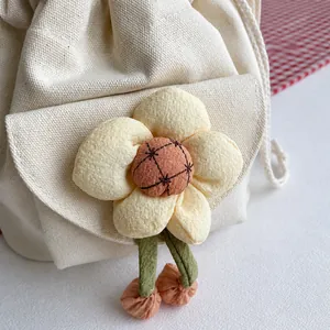 Detailed close-up of a floral canvas bucket bag with a 3D yellow flower and drawstring