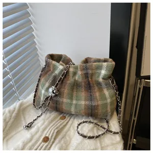 Détail du sac bandoulière en laine à carreaux avec chaîne en métal et breloque sphérique