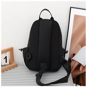 Rear view of black nylon chest bag with adjustable shoulder strap and top handle detail