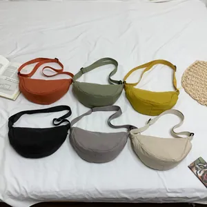 Platliggende weergave van diverse kleurrijke nylon halverwege crossbodytassen