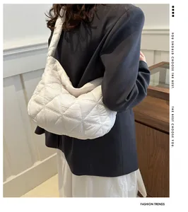 Close-up of white quilted puffer shoulder bag with elegant diamond lattice stitching