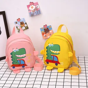 Detail of pink and yellow cartoon dinosaur mini backpacks with Follow Me Dude printing