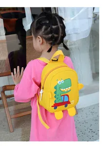 Outdoor shot of a toddler wearing a yellow mini dinosaur backpack with cartoon car design