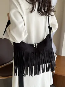 Minimalist black fringe crossbody bag in suede texture with tassel details and knot strap