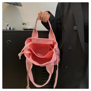 Dettaglio della borsa in tela rosa che mostra la grande capacità e i vani interni