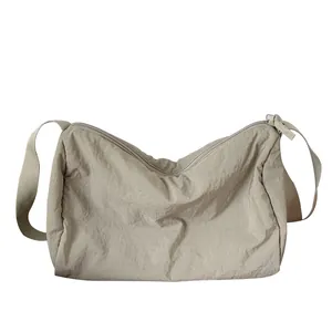 Sac bandoulière minimaliste en nylon plissé beige avec sangle réglable et fermeture éclair