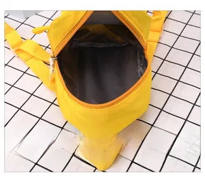 Internal view of the yellow mini backpack showing the dark grey lining and spacious main compartment