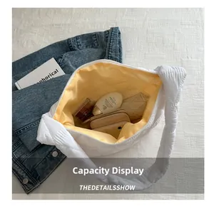 Capacity display of white quilted tote bag with bright yellow lining and spacious interior
