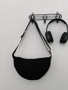 Minimalistische zwarte nylon halve maan schoudertas met verstelbare riem in studiobeeld