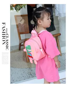 Pink toddler dinosaur backpack with 3D limb details and cartoon pattern shown on a child