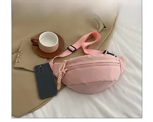 Detailed view of light pink nylon waist bag with double zippers and woven cord pullers