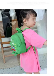 Detailed view of kids dinosaur backpack with durable green nylon and cartoon print