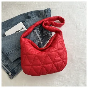 Detail of red quilted nylon crescent bag featuring triangular embroidery stitching