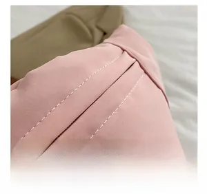 Detailed macro view of white contrast stitching on light pink casual crossbody bag