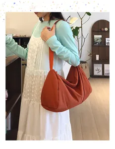 Close-up of orange nylon hobo bag on shoulder, showcasing large capacity and soft texture