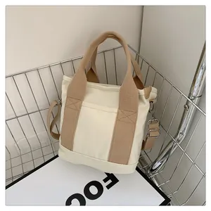 Dettaglio della borsa tote in tela con cuciture rinforzate e tracolla kaki regolabile