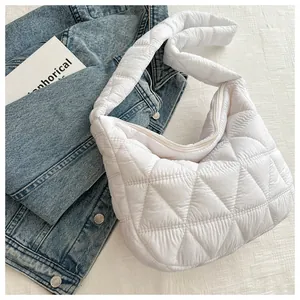 Macro detail of white quilted cloud shoulder bag featuring geometric diamond stitching